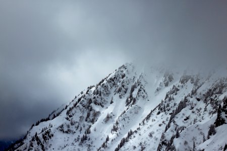 hills covered with snow over nimbus clouds photo