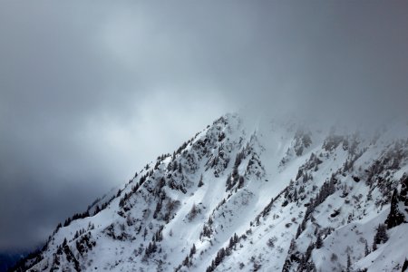 hills covered with snow over nimbus clouds