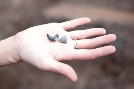three gray pebbles on person's palm