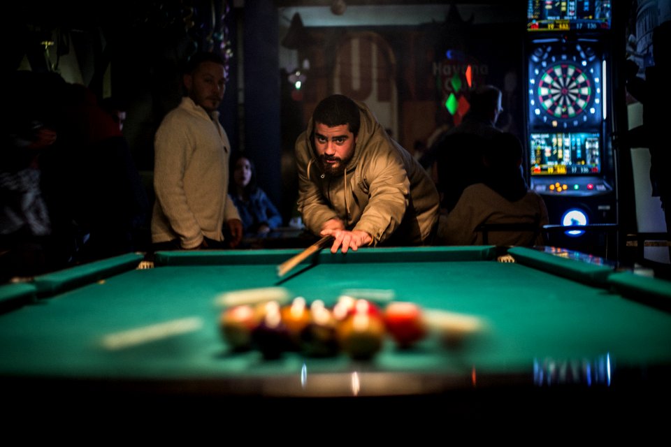man in brown jacket playing billiard