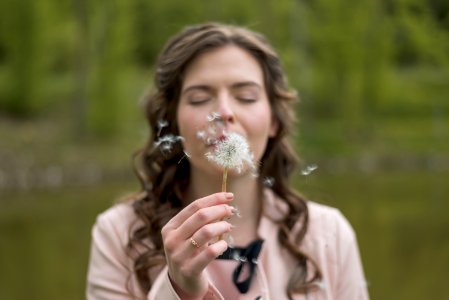woman blowing dandelion flower photo