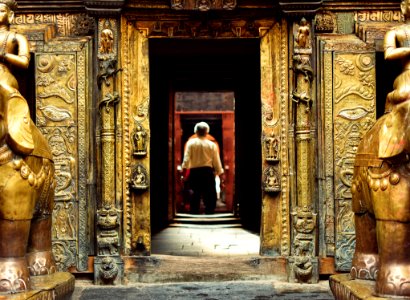 man standing in front of brown doorway during daytime photo