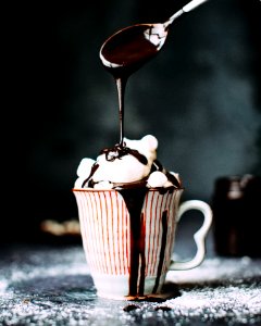 chocolate pouring on vanilla ice cream in ceramic cup