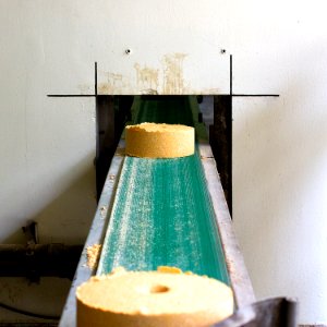 two cylindrical brown block on conveyor belt photo