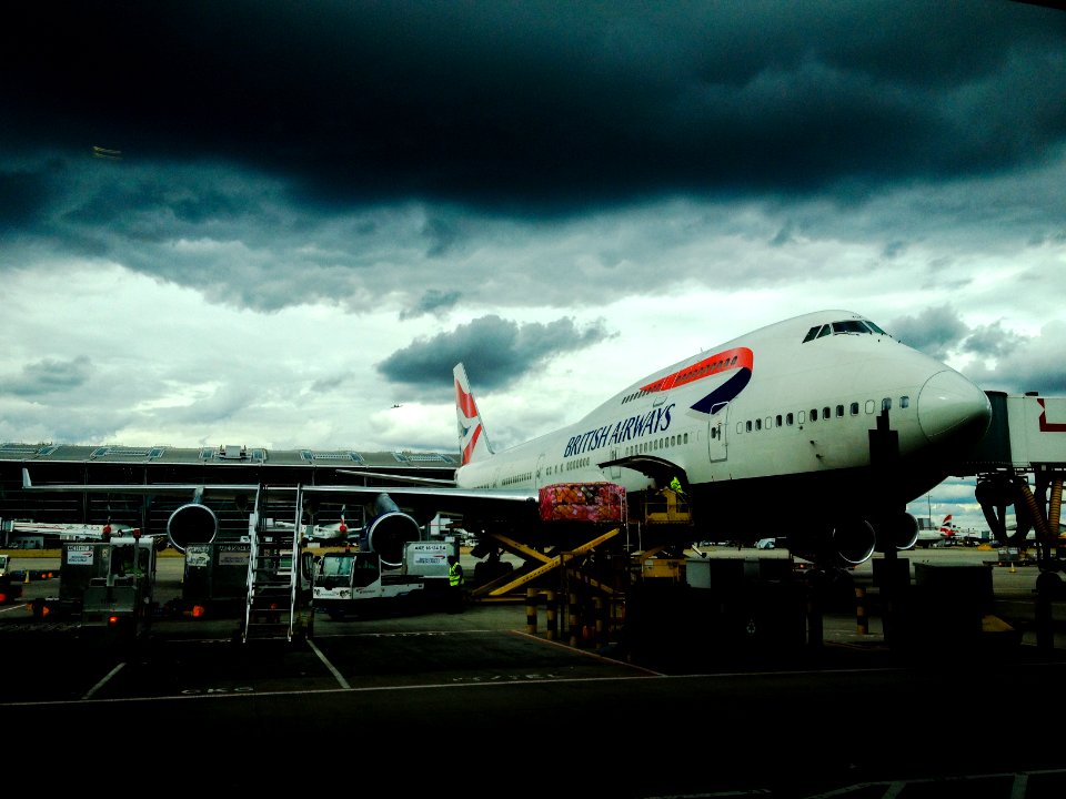 white and red airplane with cumulonimbus cloud