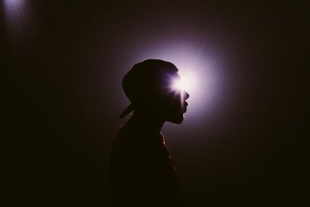 silhouette photography of man wearing cap photo