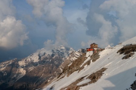 house on top of mountain under cloudy sky photo