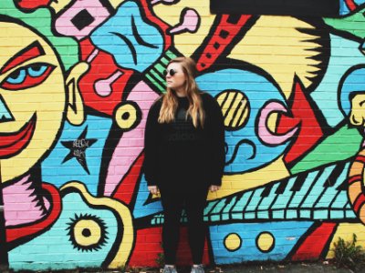 woman standing beside wall with graffiti photo