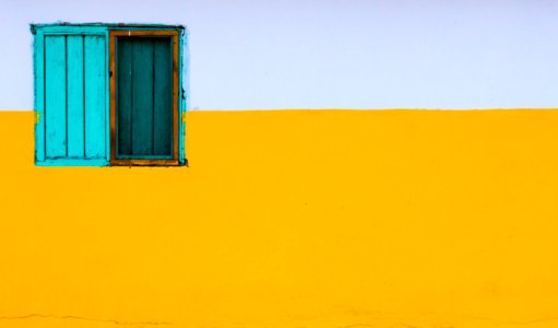yellow and white painted wall with blue window photo