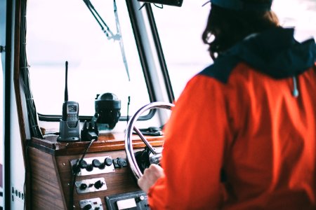 person holding steering wheel inside vehicle during daytime photo