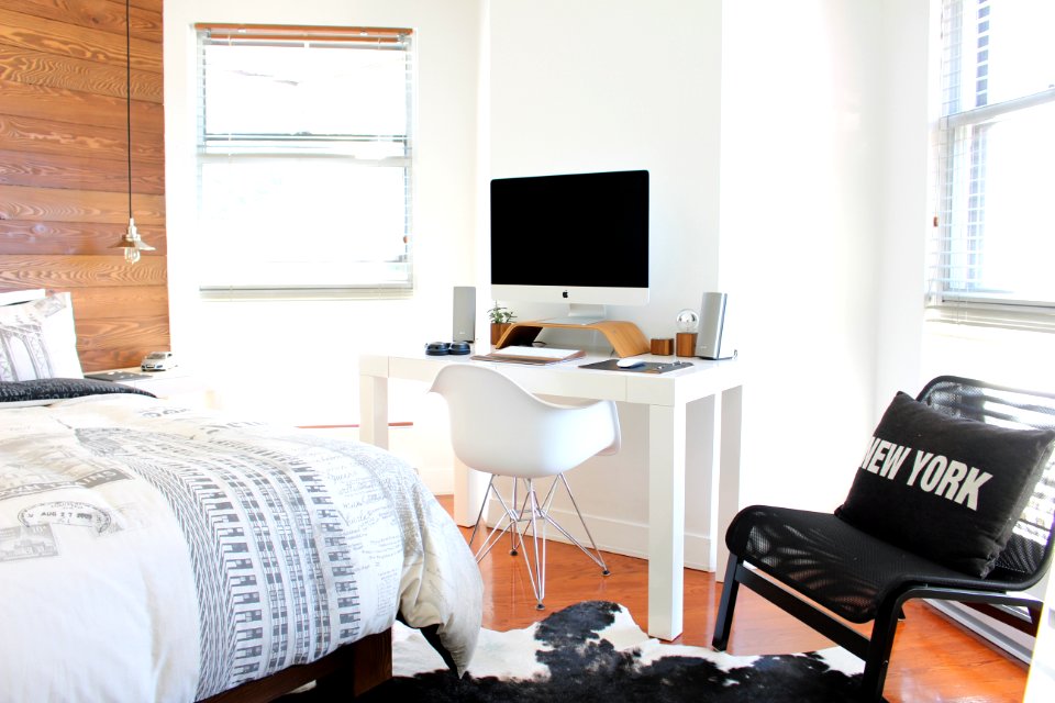 white wooden desk near bed inside the room photo