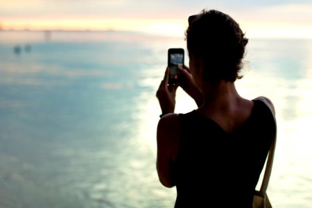 woman taking photo of body of water photo