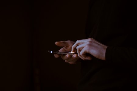silhouette photo of person holding smartphone photo