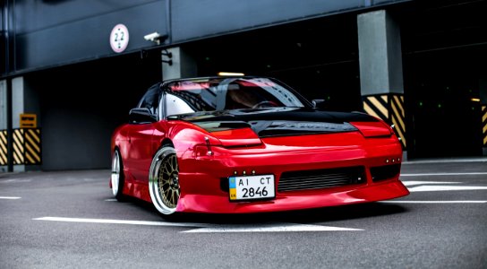 red coupe on gray concrete ground photo