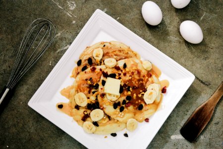 plate of pancake topped with sliced bananas and chocolate syrup photo