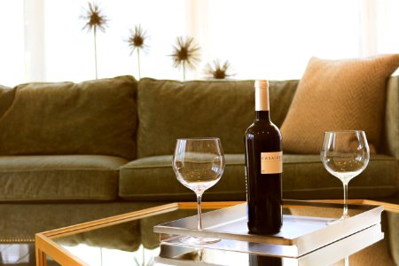 black wine bottle beside two wine glasses photo