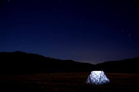 photography of lighted tent on field