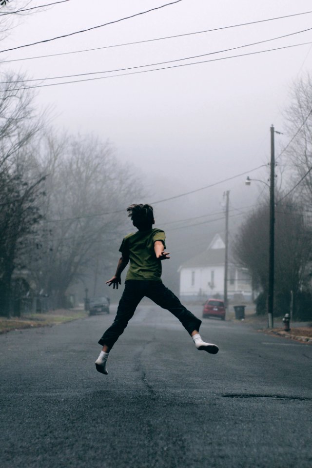 Kid jumps in the middle of the road on a foggy day