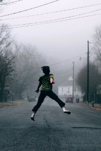 Kid jumps in the middle of the road on a foggy day
