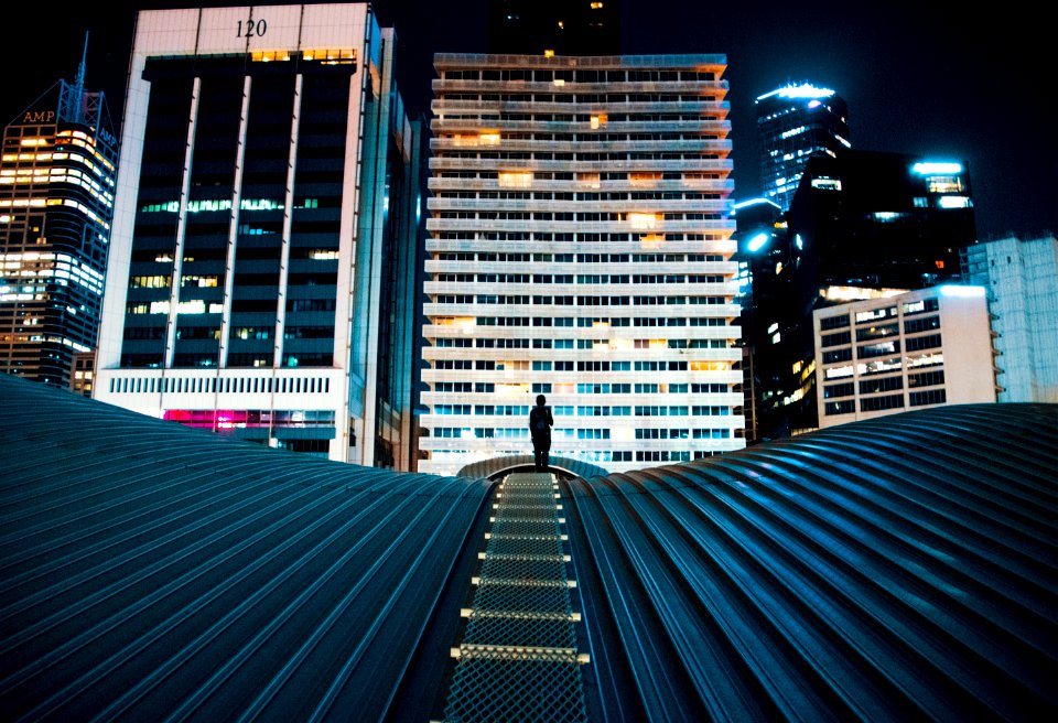 person standing on building roof with city buildings on background