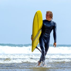 man holding yellow surfboard