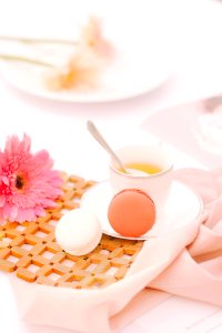 two orange and white macaroons beside white ceramic cup with spoon photo