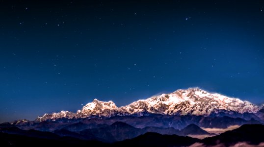 snow covered mountain under starry sky photo