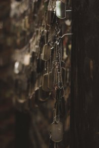 silver-colored god tags hanging on hooks shallow focus photography photo
