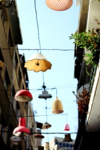 low angle photography of assorted-color lamps hang on wire between white buildings photo