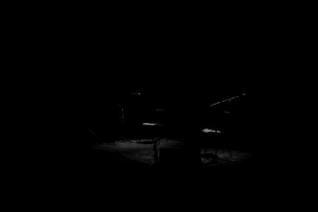 A dim shot of two chairs and microphone stands on an empty stage photo