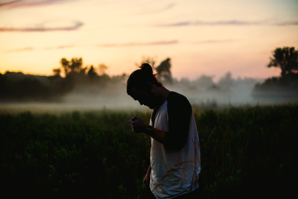 man wearing black and white raglan top on green grass field photo