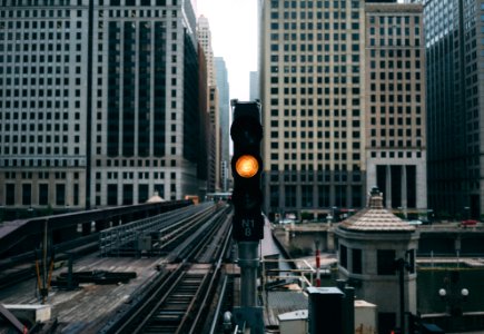 ready traffic light near railroad between buildings photo