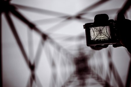 person holding DSLR camera capturing bridge photo