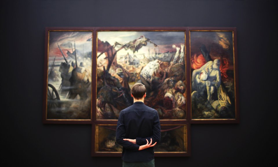 man hands on back looking on painting mounted at wall
