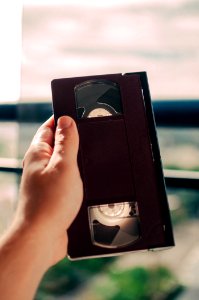 person holding black VHS tape photo