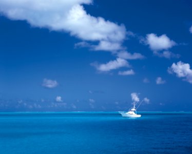 white boat on sea under cloudy sky photo