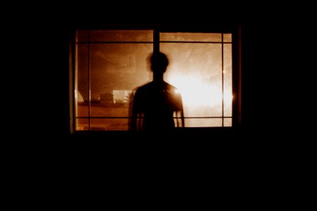 silhouette photography of person in front of window photo