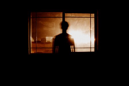 silhouette photography of person in front of window