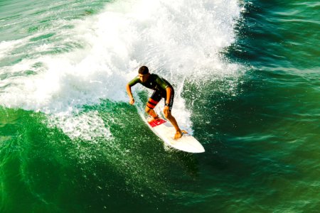 man on surfboard surfing against waves photo