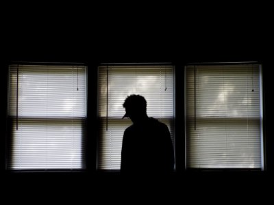 man standing infront of window blinds photo