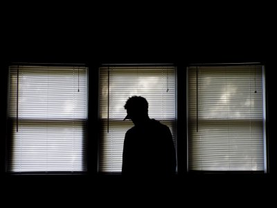 man standing infront of window blinds