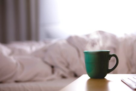 green ceramic mug on wooden desk photo