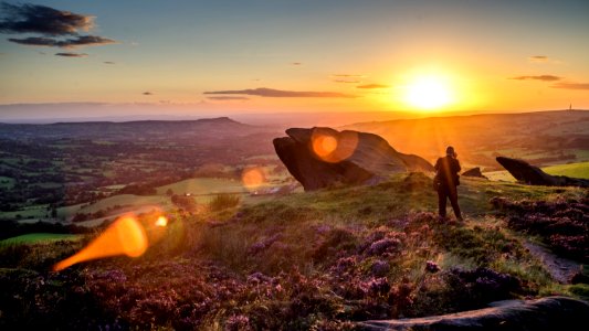 person standing near rock formation during sunset