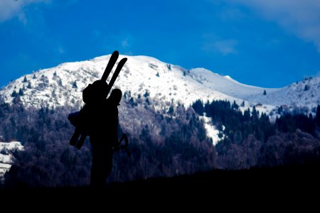 silhouette of person climbing mountain during daytime photo