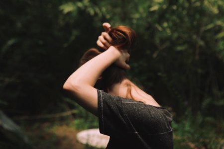 woman wearing black shirt tying up hair photo