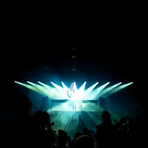 person standing under stage lights facing crowd photo