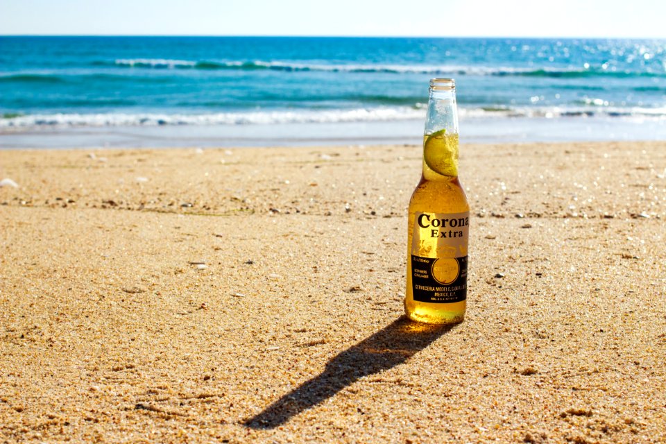 Corona Extra bottle on seashore during daytime