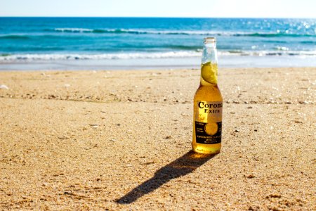 Corona Extra bottle on seashore during daytime photo
