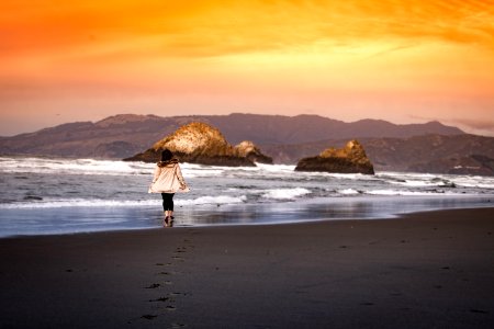 woman wearing on seashore during sunset