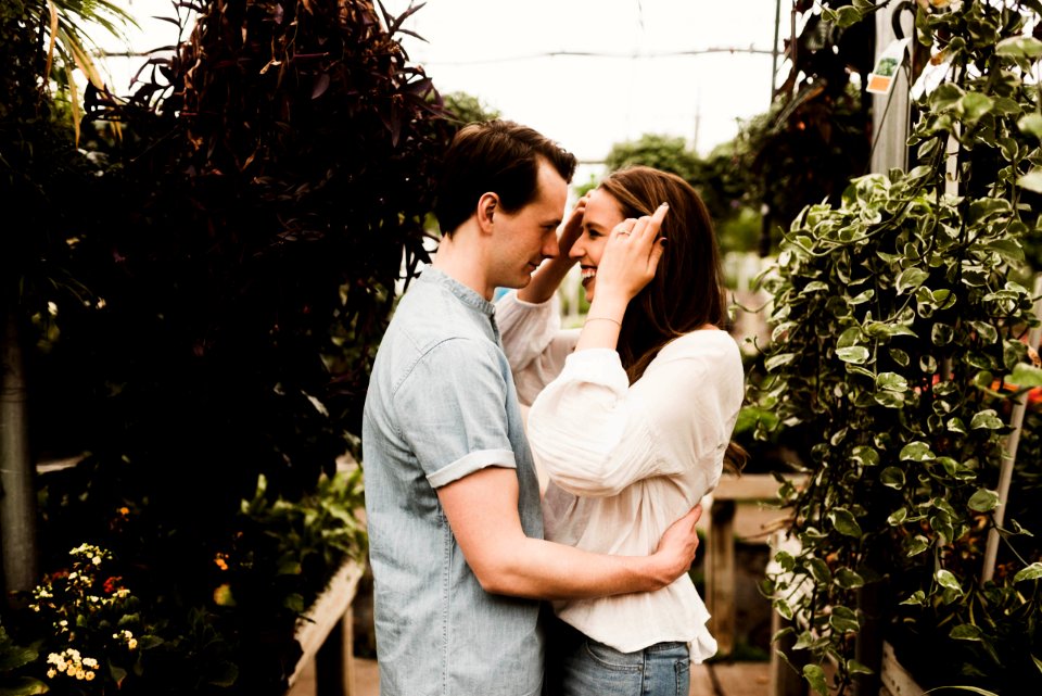 man holding waist of woman surrounded plants